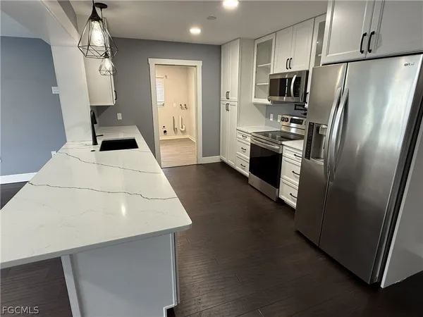 a kitchen with stainless steel appliances a refrigerator a stove a sink and a refrigerator