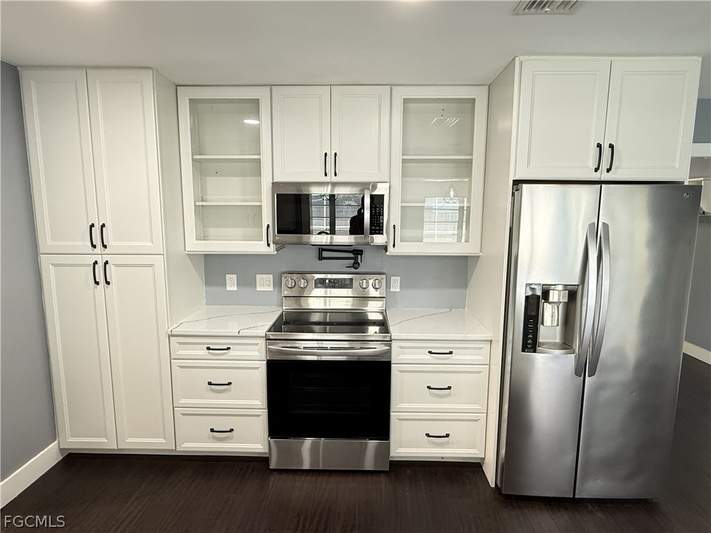 1534 Ricardo Avenue Fort Myers, FL 33901 - Photo 6 of 22 a kitchen with stainless steel appliances a refrigerator stove and cabinets