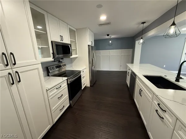 a kitchen with cabinets appliances and a sink