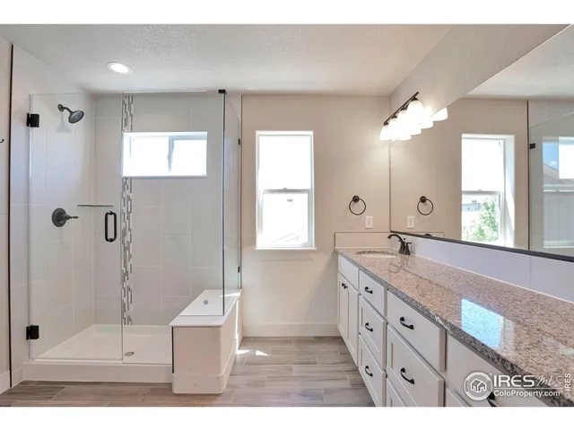a bathroom with a granite countertop sink mirror and shower