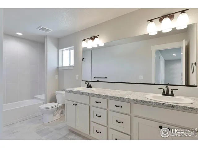 a bathroom with a double vanity sink and a mirror