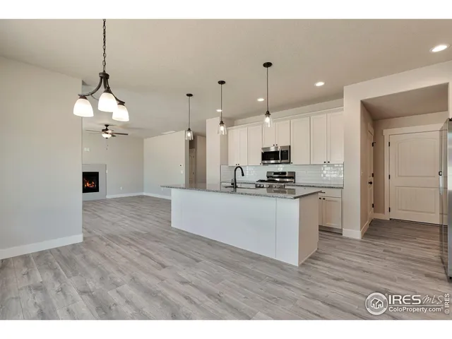 a kitchen with stainless steel appliances kitchen island a refrigerator sink and cabinets