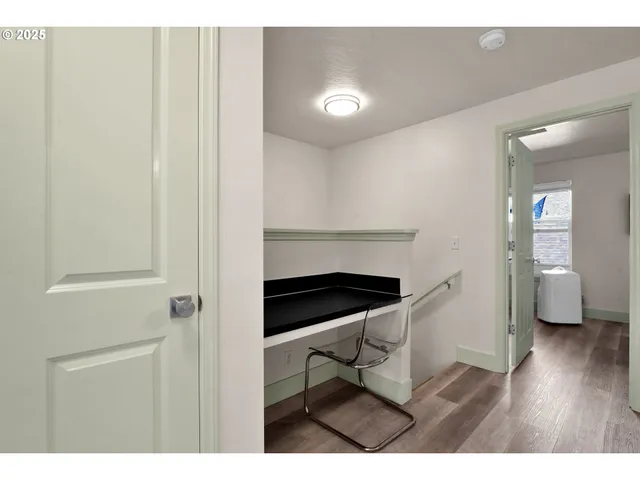 a hallway with wooden floor table and chairs