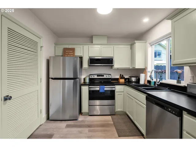 a kitchen with granite countertop a refrigerator and a stove top oven