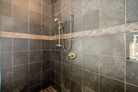 a bathroom with a granite countertop sink a mirror and a bathtub