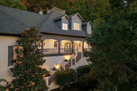 a dining room with wooden floor a chandelier a glass table and chairs