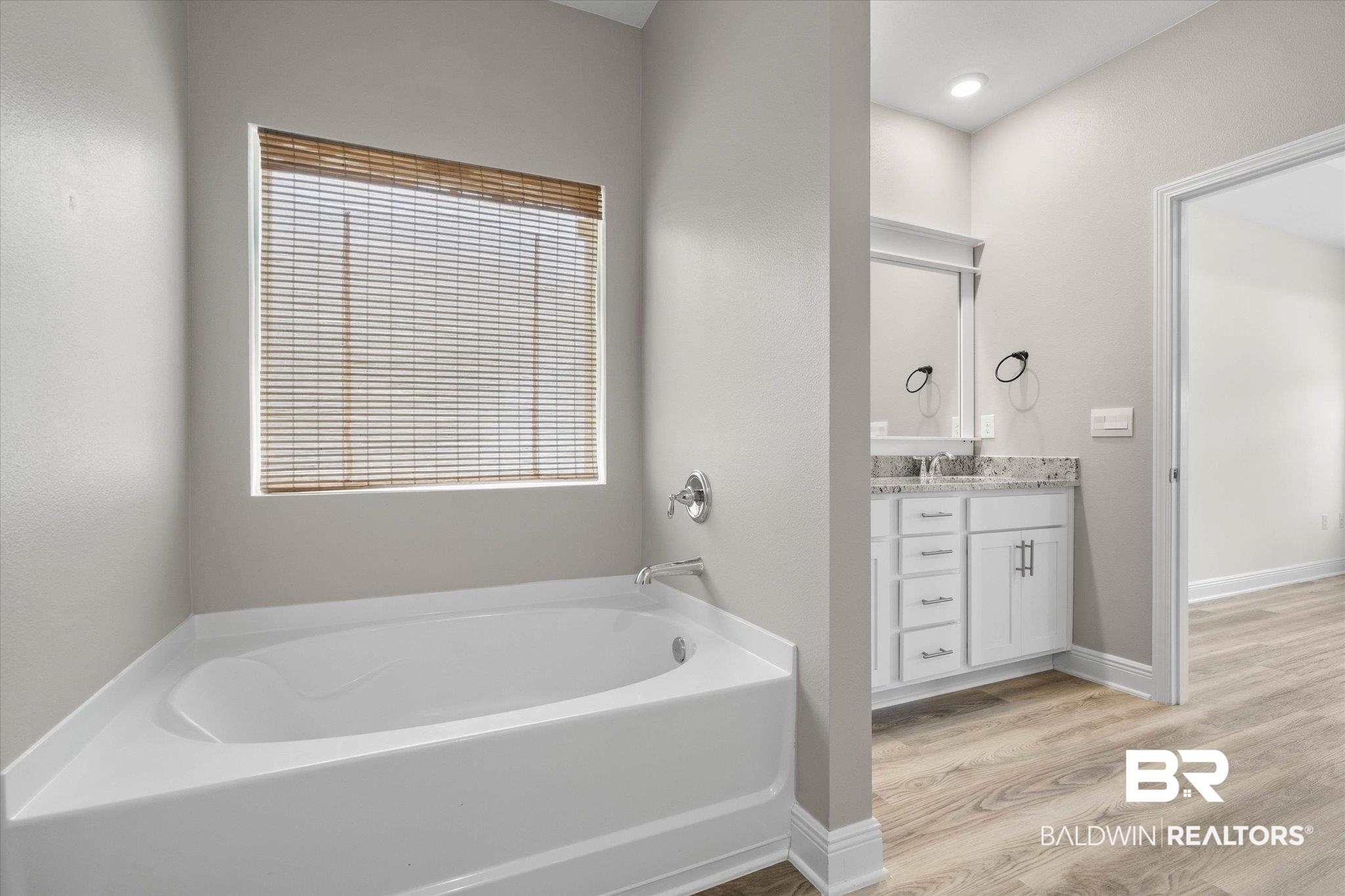 11229 Genuine Risk Circle Daphne, AL 36526 - Photo 14 of 46 Bathroom with vanity, a garden tub, and wood finished floors