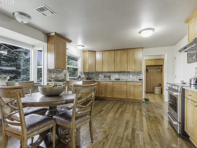 a kitchen with a sink a counter top space a stove a refrigerator cabinets and a window