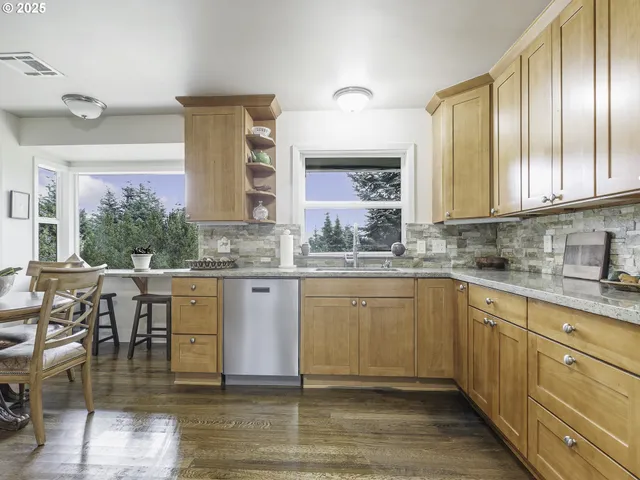 a kitchen with stainless steel appliances granite countertop a stove a sink and a granite counter tops with white cabinets