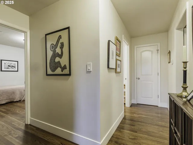 a view of a hallway with wooden floor and closet