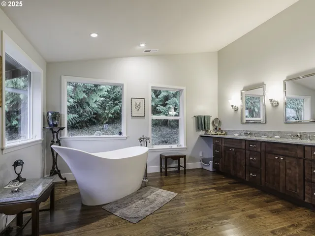 a spacious bathroom with a tub sink and mirror