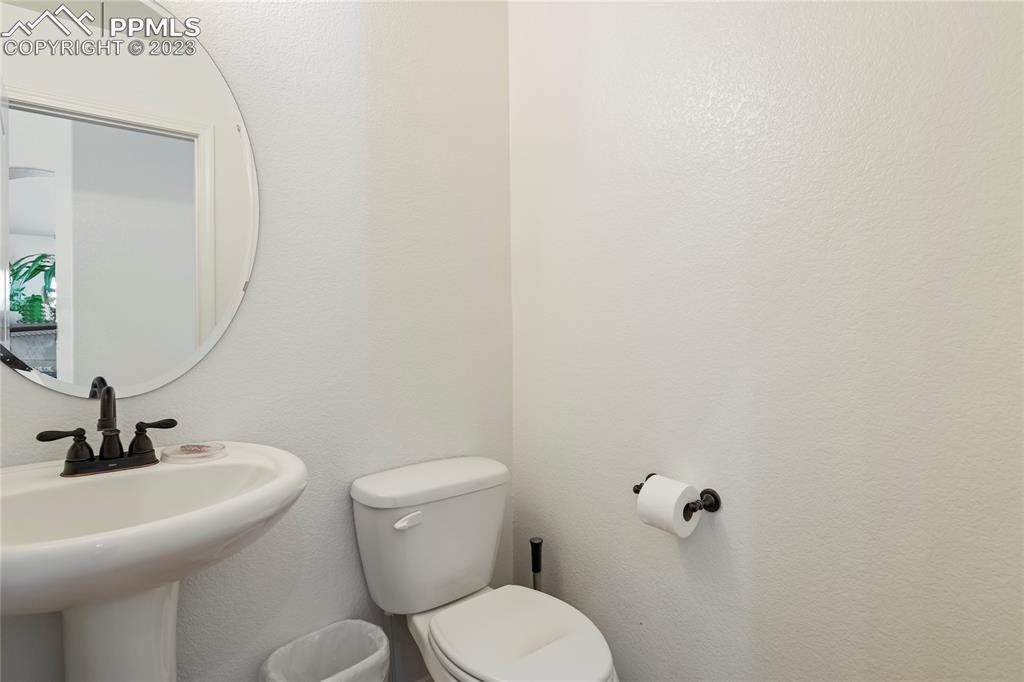 10658 Pictured Rocks Drive Peyton, CO 80831 - Photo 13 of 36 a bathroom with a toilet a sink and mirror