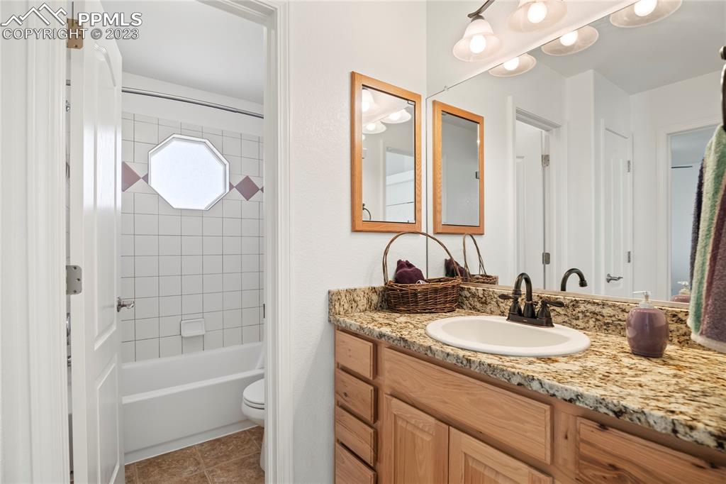 10658 Pictured Rocks Drive Peyton, CO 80831 - Photo 19 of 36 a bathroom with a granite countertop sink mirror and a bathtub