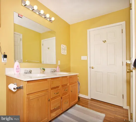 a spacious bathroom with a granite countertop sink a mirror and a shower