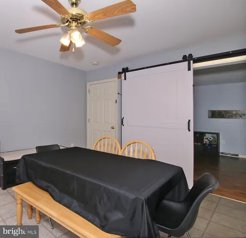 a living room with a table chairs and a refrigerator