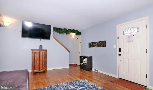 a view of a livingroom with wooden floor and a flat screen tv