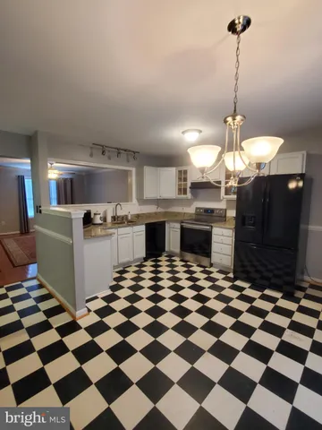 a kitchen with a checkered floor and white cabinets
