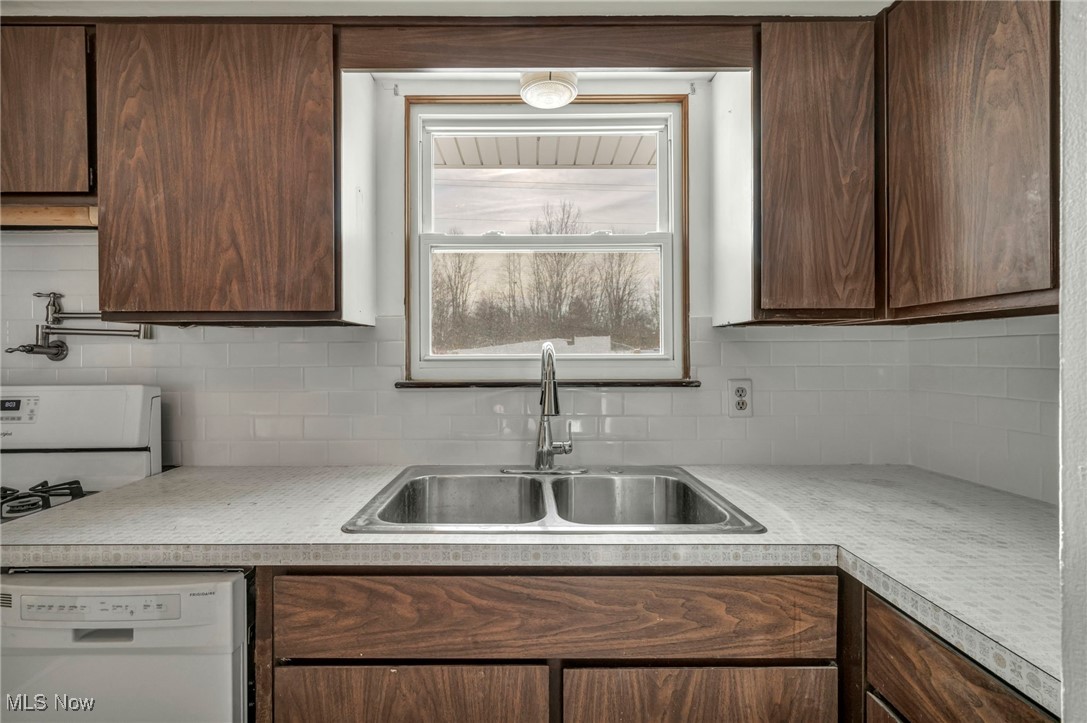 2514 Primewood Road Akron, OH 44305 - Photo 14 of 49 Kitchen featuring white appliances, light countertops, tasteful backsplash, and dark brown cabinets
