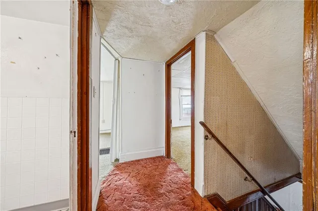 a view of hallway with wooden floor and stairs
