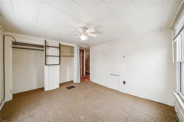 an empty room with windows and closet