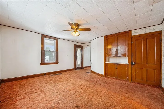 an empty room with windows and cabinet