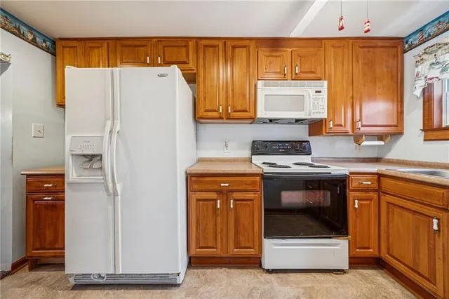 a kitchen with a refrigerator sink and cabinets