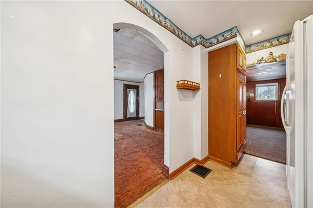 a view of a hallway with wooden floor and a bathroom