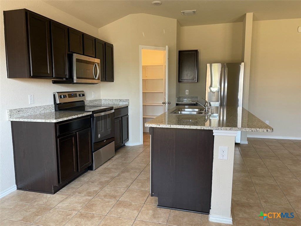 6114 Sally Ride Lane Killeen, TX 76543 - Photo 5 of 21 a kitchen with stainless steel appliances granite countertop a refrigerator and a stove top oven