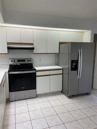 a kitchen with a stove a refrigerator and cabinets