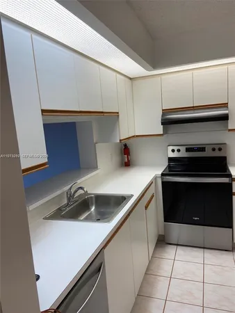 a kitchen with a sink and white cabinets