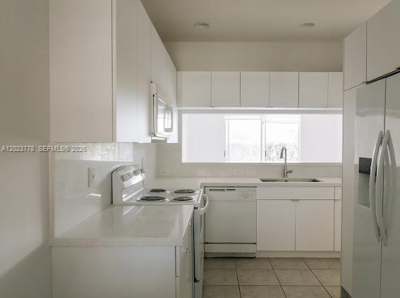 10245 Vía Hibiscus, Unit 10245 Boca Raton, FL 33428 - Photo 5 of 28 a kitchen with a sink a refrigerator and cabinets
