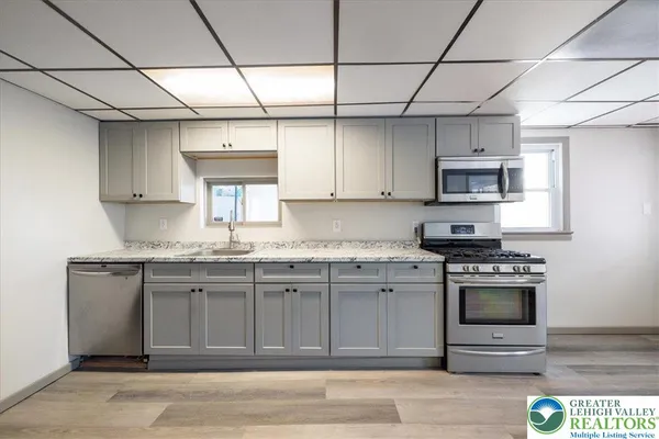 a kitchen with stainless steel appliances granite countertop a stove a sink and a microwave