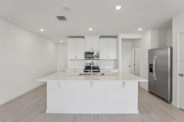 a kitchen with stainless steel appliances granite countertop a sink a refrigerator and a stove