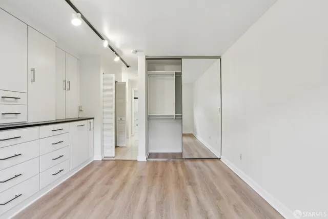 a front view of multi story residential apartment building with yard and bench