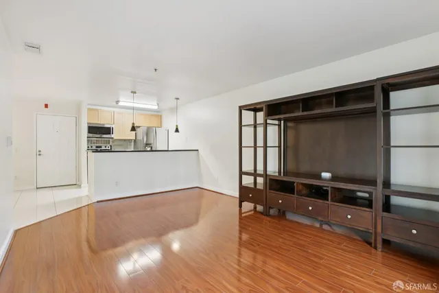 a view of a kitchen with wooden floor and a window