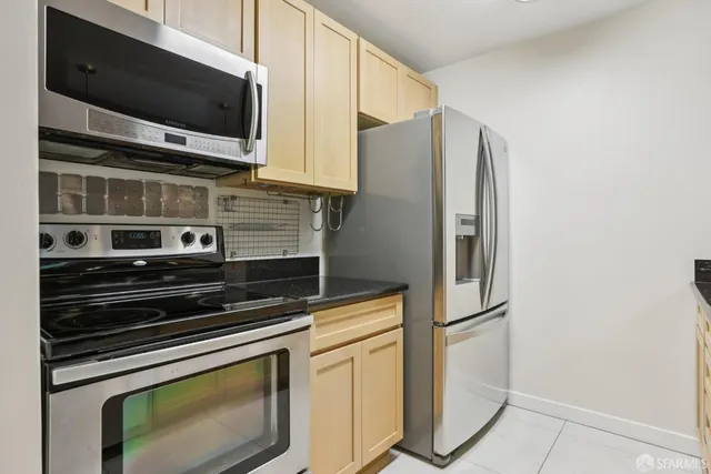 a kitchen with stainless steel appliances a stove microwave and refrigerator