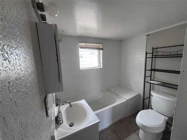 a white toilet sitting next to a bath tub