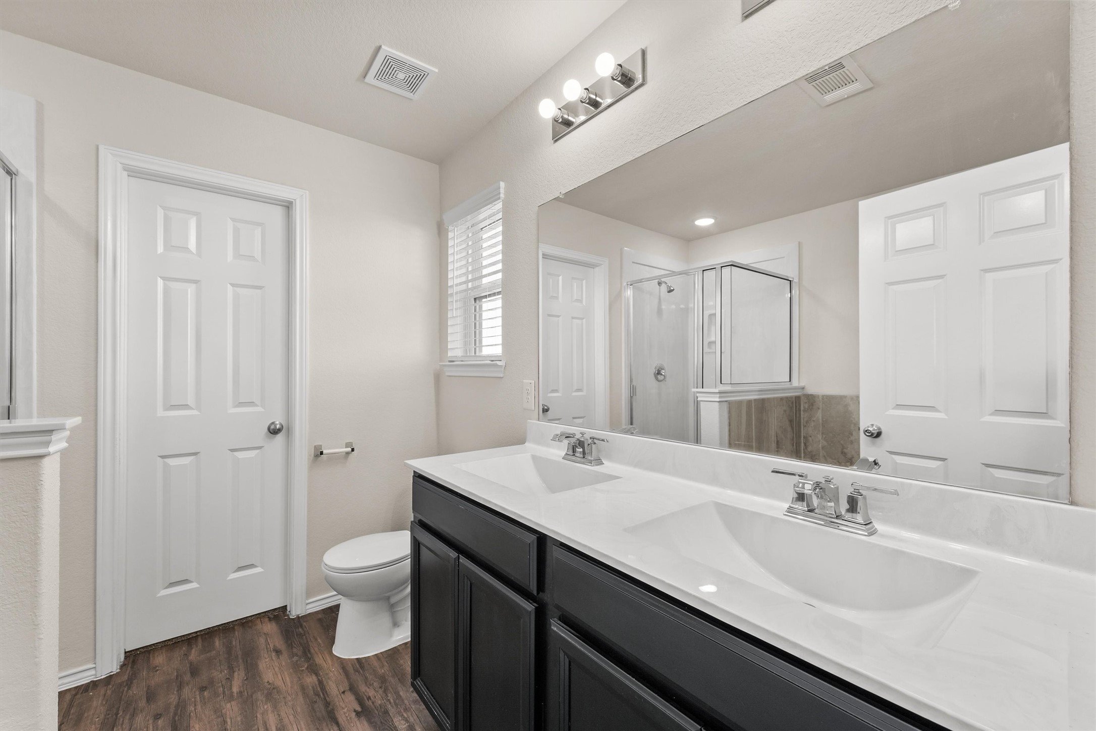 5710 Pampus Prairie Road Katy, TX 77493 - Photo 16 of 27 a bathroom with a double vanity sink a mirror and a toilet