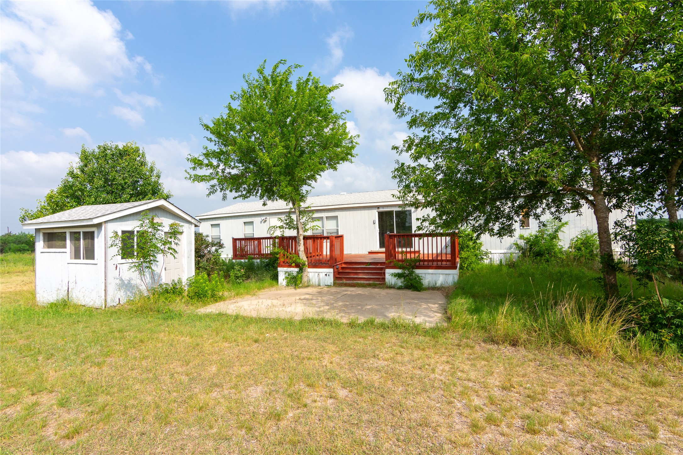 1 11209-tract Road Del Valle, TX 78617 - Photo 27 of 39 Back of house featuring a wooden deck, an outdoor structure, and a yard