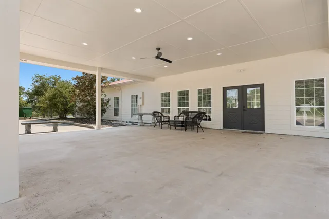 a living room with lots of furniture a table and kitchen view