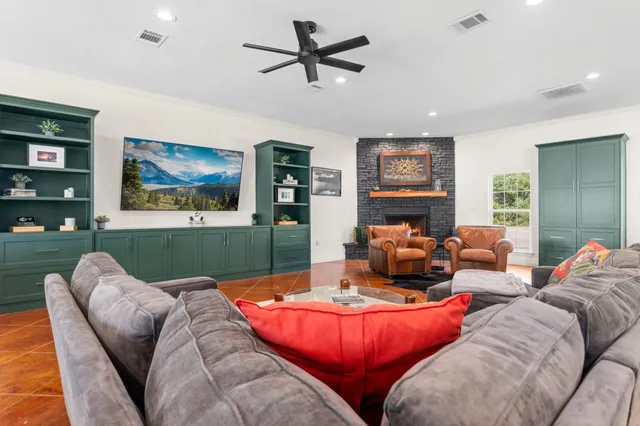 a living room with dining table tennis table and a potted plant