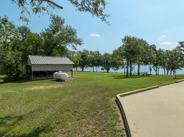 a backyard of a house with table and chairs under an umbrella