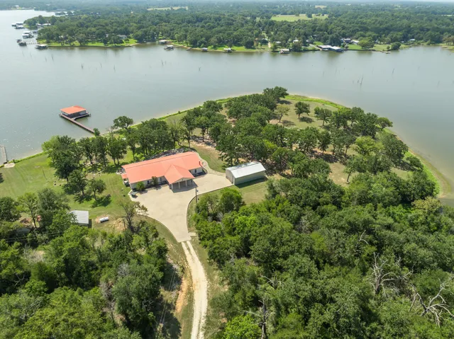 an aerial view of house with yard and lake view