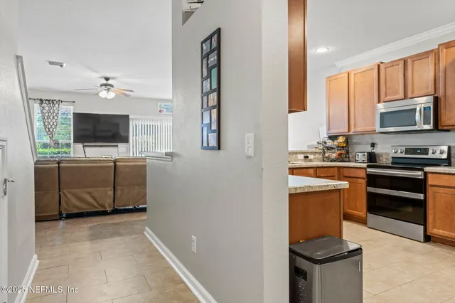 a large kitchen with stainless steel appliances granite countertop a stove a sink dishwasher and a refrigerator