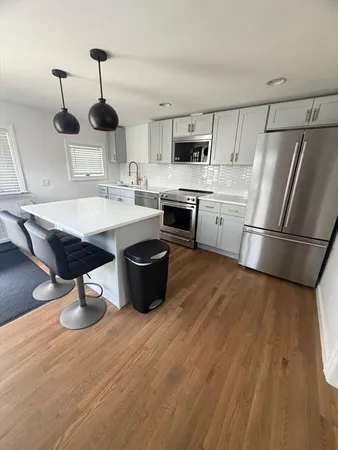 a kitchen with stainless steel appliances granite countertop a sink a stove and a refrigerator