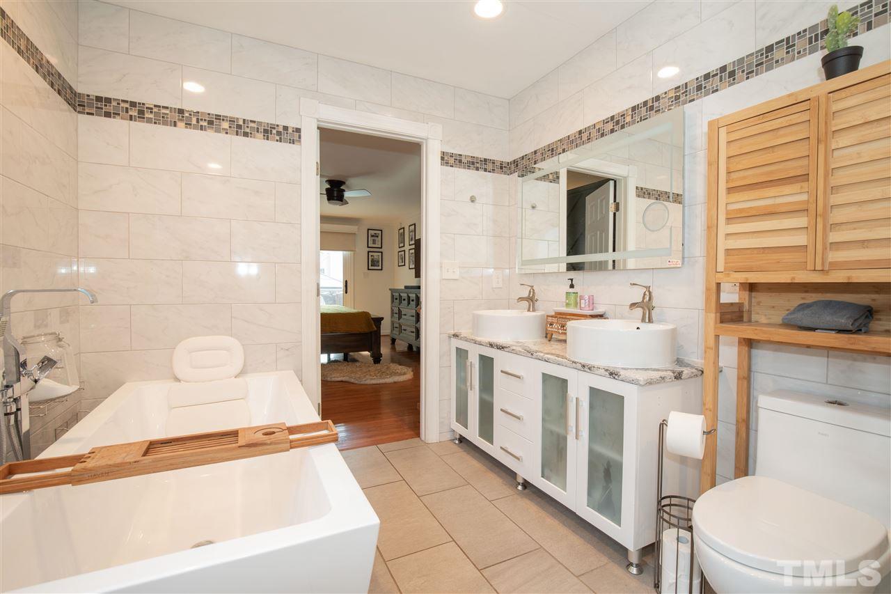 715 Rosemont Avenue Raleigh, NC 27607 - Photo 14 of 26 a bathroom with a sink a toilet a mirror and shower