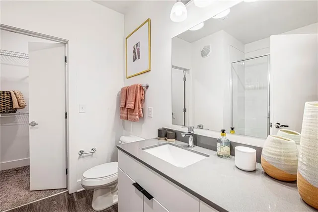 a bathroom with a granite countertop sink mirror vanity and toilet