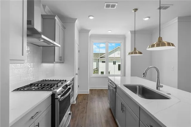 a kitchen with stainless steel appliances a sink stove and refrigerator