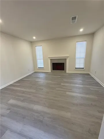 an empty room with wooden floor and fireplace