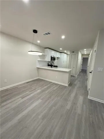 a view of a kitchen with a sink and wooden floor
